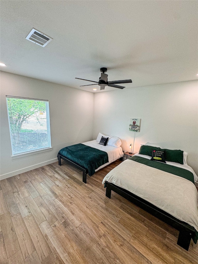 bedroom with ceiling fan and light wood-type flooring