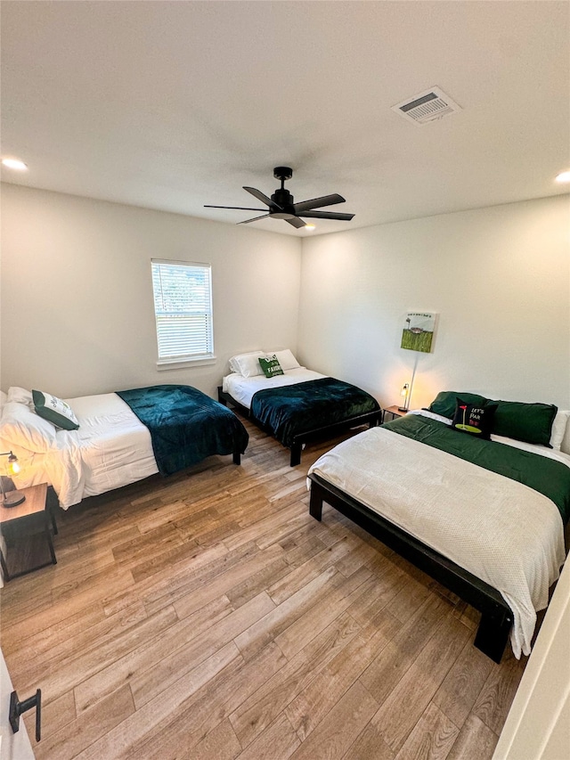 bedroom with light hardwood / wood-style floors and ceiling fan