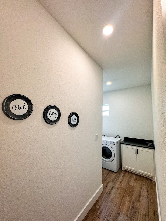 laundry room featuring cabinets, washer / dryer, and dark hardwood / wood-style flooring