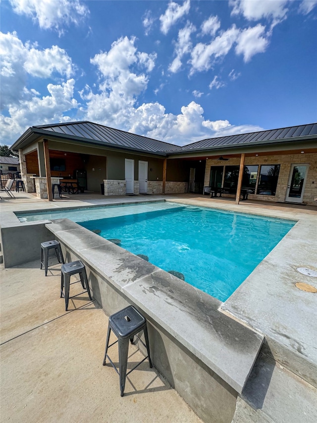 view of pool featuring a diving board and a patio