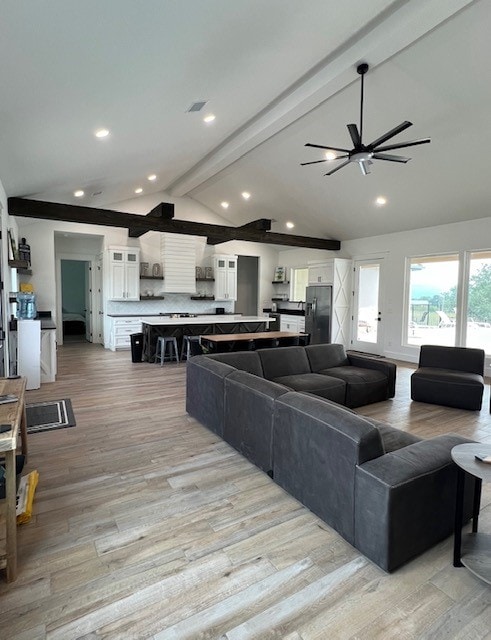 living room with lofted ceiling with beams, light hardwood / wood-style floors, and ceiling fan