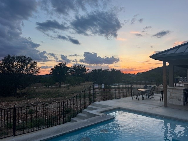 view of pool at dusk