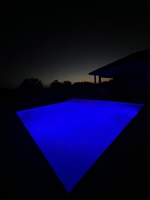 view of pool at twilight