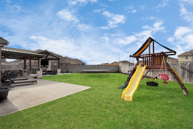 view of play area featuring a lawn, a patio area, a pergola, and a trampoline