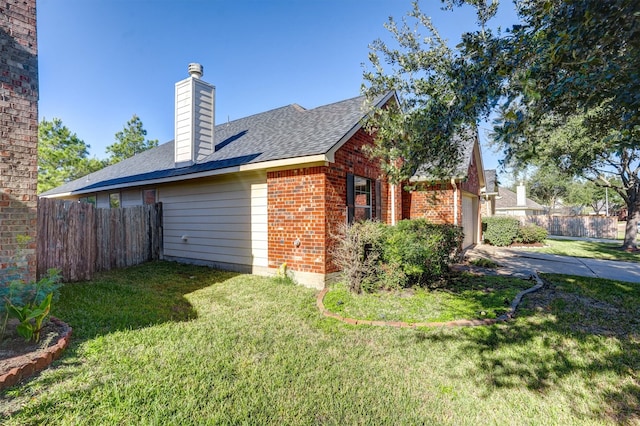 view of side of property with a yard and a garage