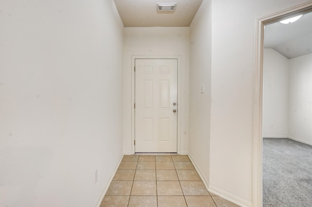 corridor featuring light tile patterned floors and lofted ceiling