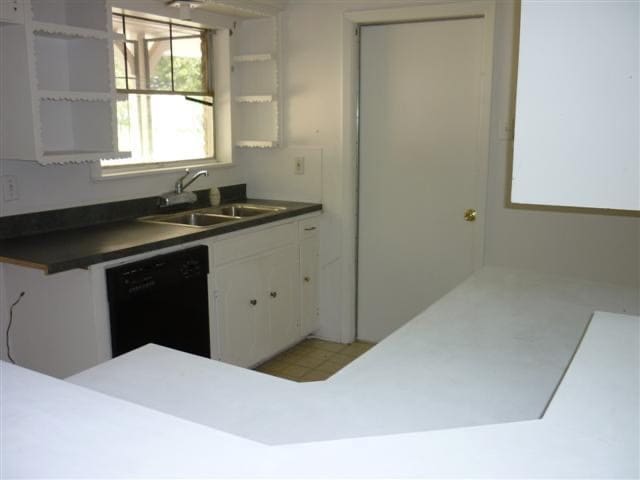 kitchen with white cabinets, black dishwasher, and sink