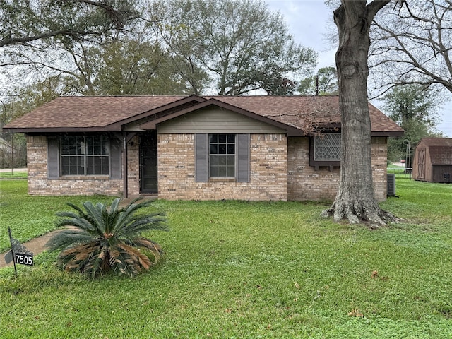 ranch-style home with a front yard and a storage shed