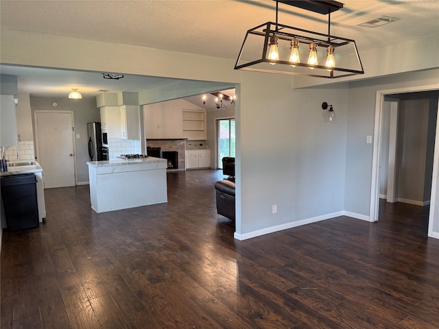 kitchen featuring backsplash, stainless steel fridge, black dishwasher, dark hardwood / wood-style flooring, and white cabinetry