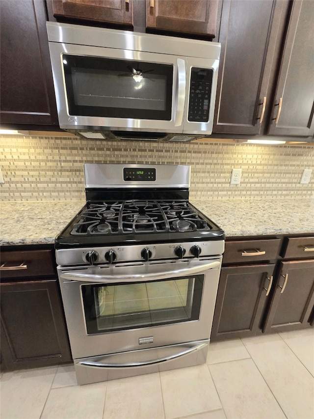 kitchen featuring backsplash, light tile patterned floors, and stainless steel appliances