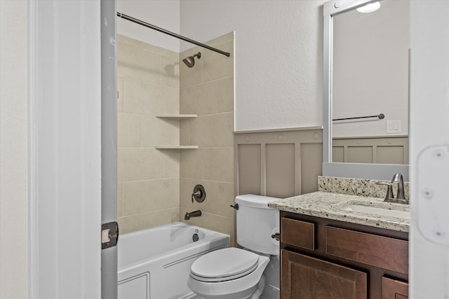 full bathroom featuring vanity, tiled shower / bath combo, and toilet