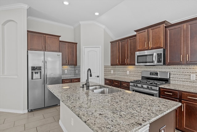 kitchen with a kitchen island with sink, lofted ceiling, sink, and appliances with stainless steel finishes