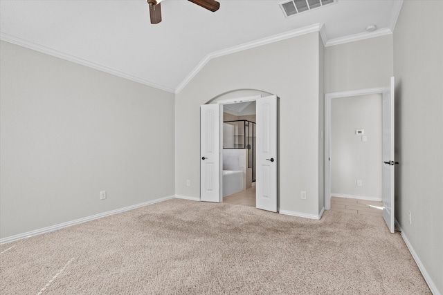 unfurnished bedroom featuring connected bathroom, ceiling fan, crown molding, lofted ceiling, and light carpet