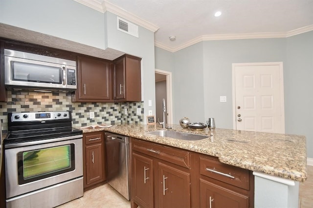 kitchen with kitchen peninsula, appliances with stainless steel finishes, light stone counters, and crown molding