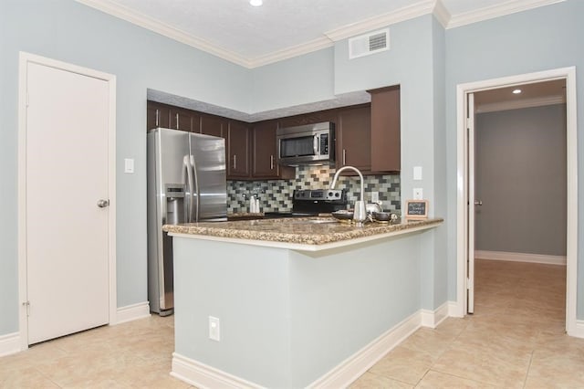 kitchen with appliances with stainless steel finishes, dark brown cabinetry, tasteful backsplash, and ornamental molding