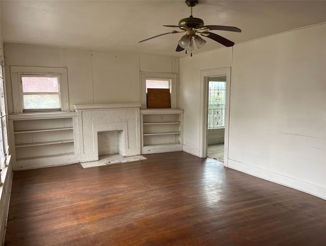 unfurnished living room featuring ceiling fan and dark wood-type flooring