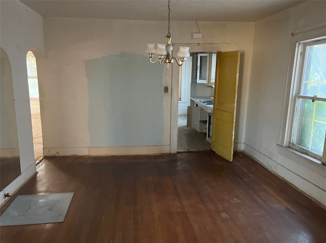 unfurnished dining area with an inviting chandelier and dark wood-type flooring