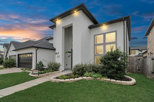 view of front of property featuring a garage and a yard