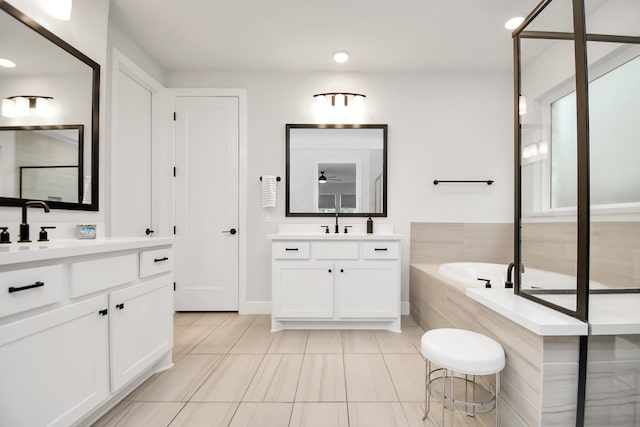 bathroom with vanity, tile patterned floors, and tiled tub