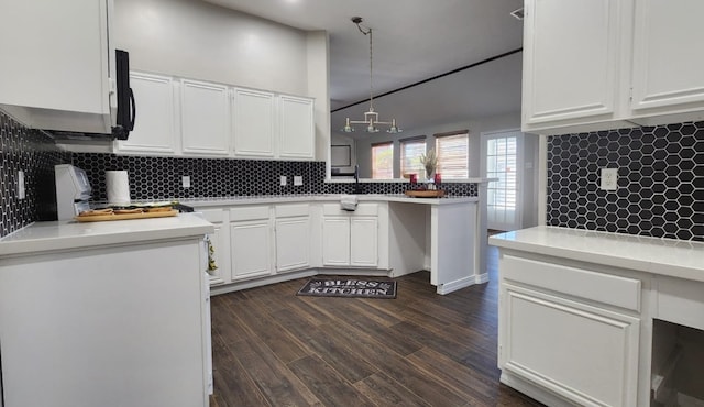 kitchen featuring white cabinets, dark hardwood / wood-style flooring, backsplash, and kitchen peninsula