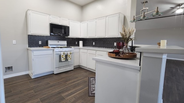 kitchen featuring kitchen peninsula, backsplash, white range with gas cooktop, dark wood-type flooring, and white cabinetry