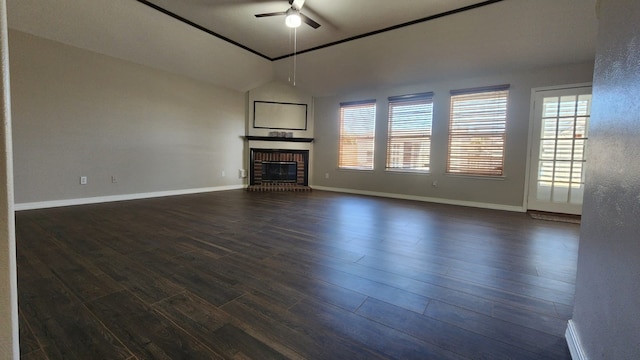 unfurnished living room with a brick fireplace, a healthy amount of sunlight, dark hardwood / wood-style flooring, and vaulted ceiling