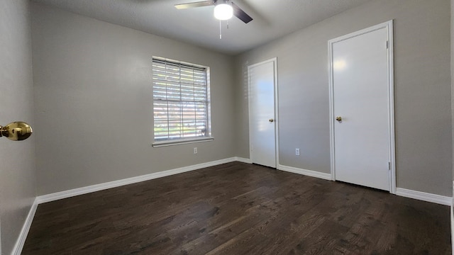 unfurnished bedroom with a textured ceiling, ceiling fan, and dark wood-type flooring