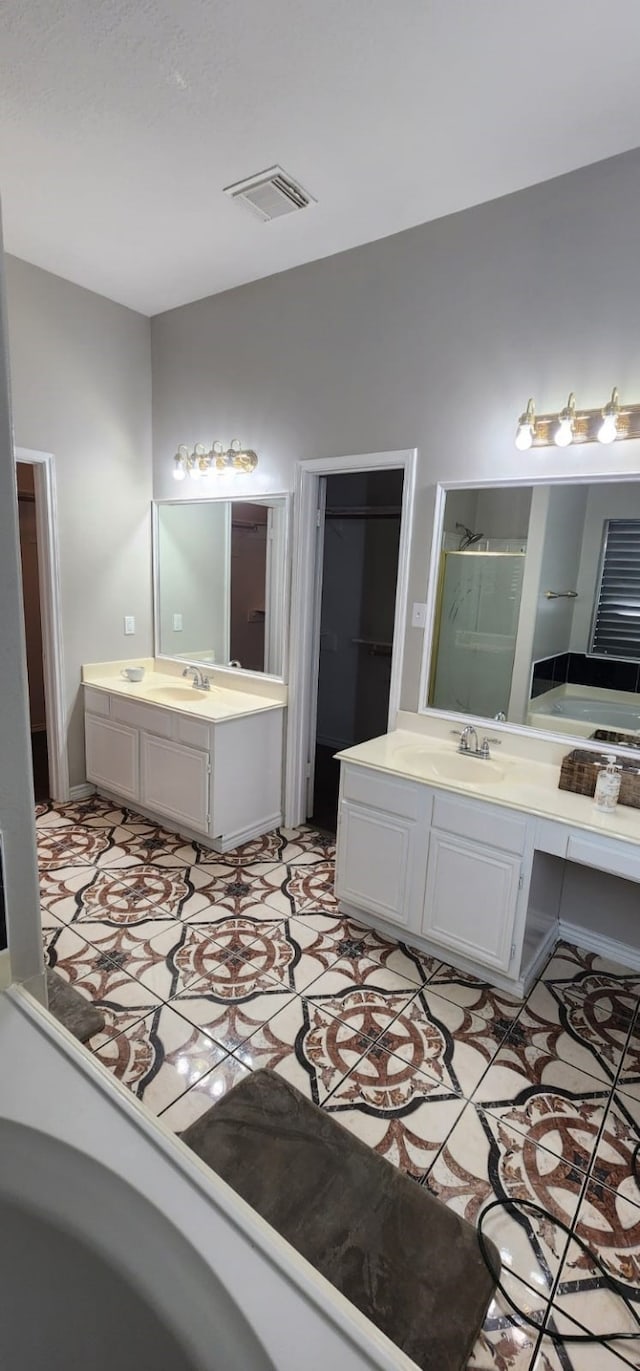 bathroom featuring vanity and independent shower and bath