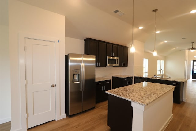 kitchen with a center island, ceiling fan, kitchen peninsula, hanging light fixtures, and appliances with stainless steel finishes