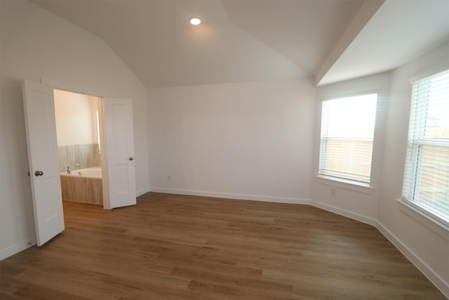 unfurnished bedroom featuring dark wood-type flooring and vaulted ceiling