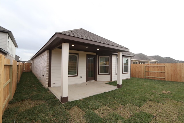 rear view of property with a patio and a lawn