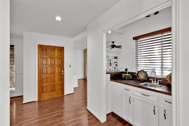 bar with white cabinets, dark hardwood / wood-style floors, ceiling fan, and sink