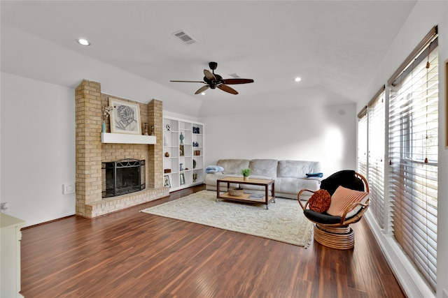 living room with hardwood / wood-style floors, ceiling fan, and a brick fireplace