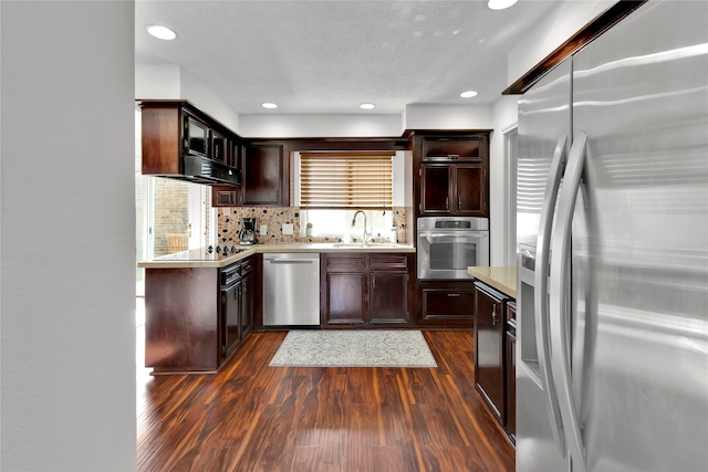 kitchen with backsplash, dark hardwood / wood-style flooring, sink, and appliances with stainless steel finishes