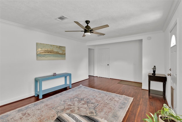 sitting room with dark hardwood / wood-style floors, ceiling fan, crown molding, and a textured ceiling