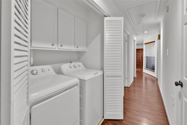 clothes washing area featuring cabinets, dark hardwood / wood-style flooring, and separate washer and dryer