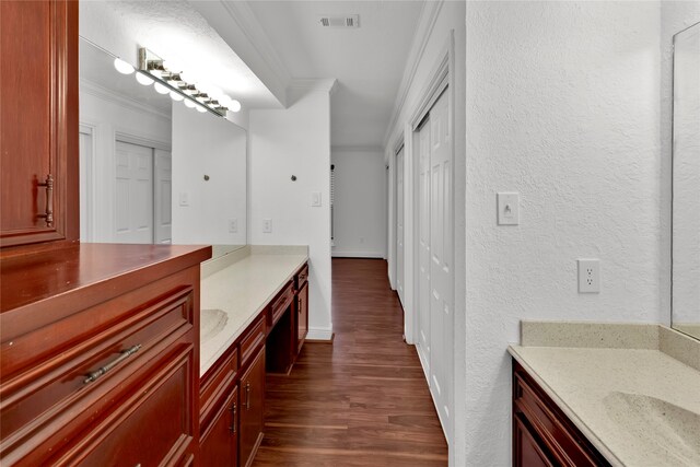 bathroom featuring vanity, hardwood / wood-style flooring, and crown molding