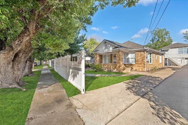 bungalow-style house featuring a front lawn