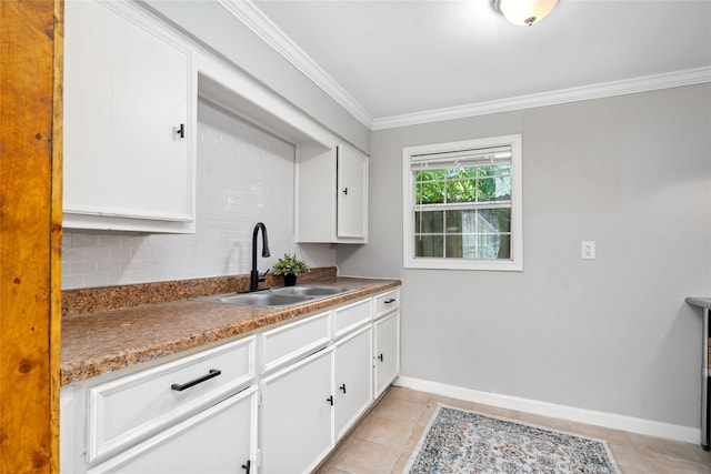 kitchen with backsplash, crown molding, sink, white cabinetry, and light tile patterned flooring