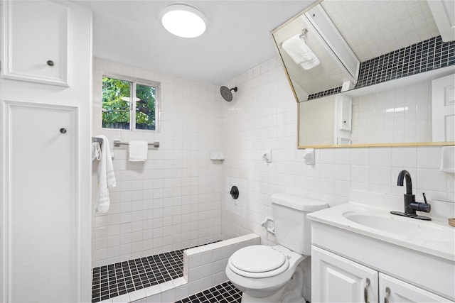 bathroom with a tile shower, backsplash, toilet, vanity, and tile walls