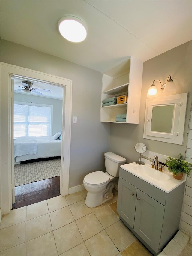 bathroom with tile patterned flooring, vanity, toilet, and ceiling fan