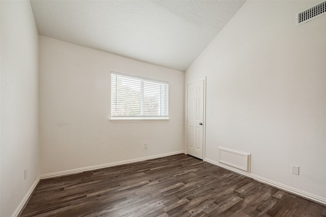 unfurnished room featuring a textured ceiling, dark wood-type flooring, and vaulted ceiling