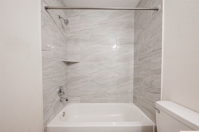 bathroom with tiled shower / bath combo and toilet