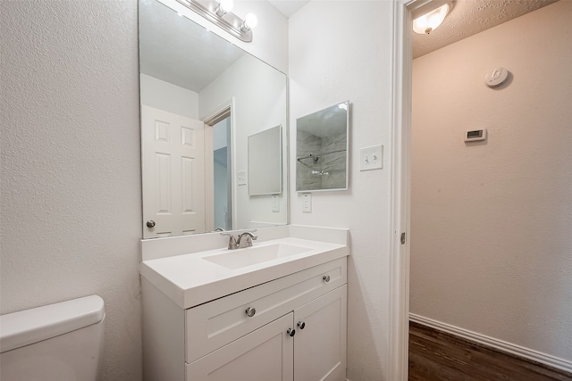 bathroom with vanity, hardwood / wood-style flooring, and toilet