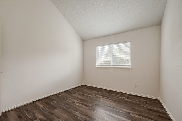 unfurnished room featuring a textured ceiling, vaulted ceiling, and dark wood-type flooring