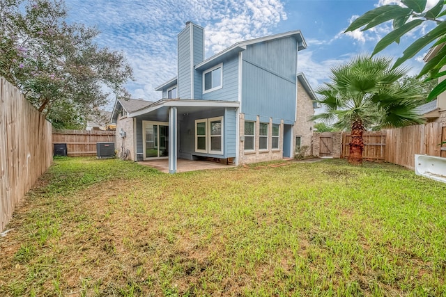 back of property featuring central air condition unit, a patio area, and a lawn