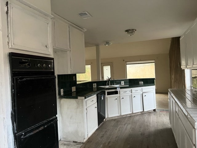 kitchen featuring black appliances, sink, white cabinets, and dark wood-type flooring