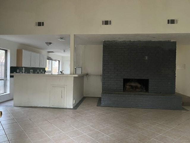 unfurnished living room with light tile patterned floors and a fireplace