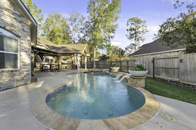 view of pool featuring an in ground hot tub, a patio, pool water feature, and exterior bar