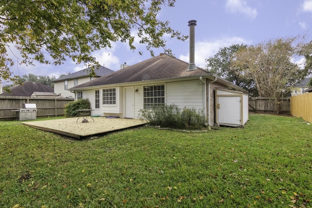 rear view of house featuring a wooden deck and a yard